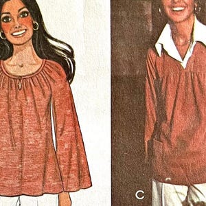 May include: Two views of a long-sleeved, rust-coloured blouse with a gathered neckline and bell sleeves. The blouse is shown on a model in both views.