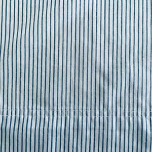 Op de afbeelding: Close-up van een stof met verticale strepen in teal en wit. De strepen zijn gelijkmatig verdeeld en lopen over de lengte van de stof. Een horizontale naad met witte stiksels is zichtbaar aan de onderkant. De stof lijkt katoen te zijn.