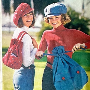 May include: Two women wearing matching hats and carrying bags. One woman wears a red hat and carries a red bag with a white floral pattern. The other woman wears a blue hat and carries a blue drawstring bag with red buttons.