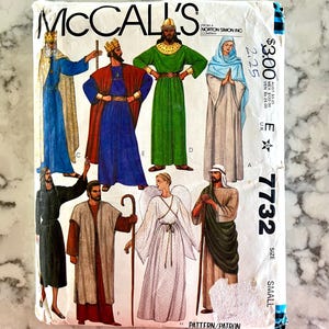 May include: A vintage McCall's sewing pattern with illustrations of religious figures in robes. The pattern shows kings, angels, and other characters. The pattern number is 7732, size small.