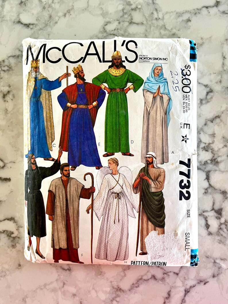 May include: A vintage McCall's sewing pattern with illustrations of religious figures in robes. The pattern shows kings, angels, and other characters. The pattern number is 7732, size small.