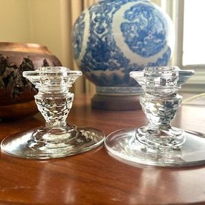 Pair of 1960&#39;s Fostoria American (2056) pressed clear glass low taper candleholders, wide bases; each 3&quot; tall x4.25&quot; in diameter at base.