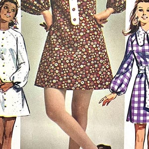 May include: Three vintage dress patterns featuring different styles. The first dress is white with a button-up front and puffed sleeves. The second dress is brown with a floral print and a Peter Pan collar. The third dress is purple and white gingham with a white sash and a Peter Pan collar.