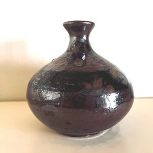 Precioso jarrón pequeño para una sola flor, de cerámica artística con esmalte jaspeado en tonos malva empolvado, negro, marrón topo y algo de óxido, firmado.