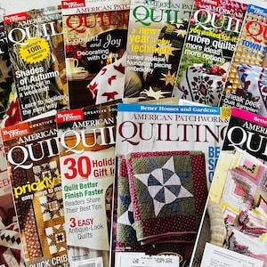 May include: A collection of American Patchwork & Quilting magazines featuring various cover designs with colorful quilt patterns, instructional text, and photography of quilted projects, stacked together in a layered arrangement.