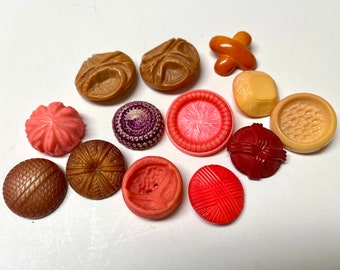 Lot of 13 large antique and vintage buttons in warm colors of red, orange, pink, all shank back except for 1; smallest 1.25", largest 1.75".