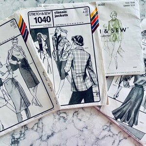 May include: Four vintage sewing patterns for jackets and skirts. The patterns are printed on white paper with black and white illustrations. The patterns are titled "Stretch & Sew Classic Jackets", "I & Sew", "Pleated Skirts", and "8-Gore Skirts".