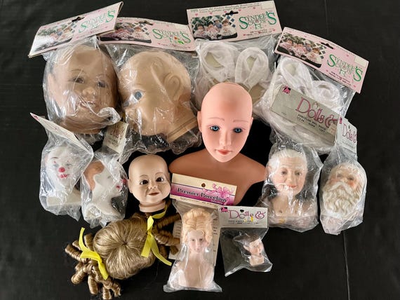 Vintage doll heads in all sizes and forms, some porcelain, some plastic, some adults, some pixies, some children, doll bodies, doll wig.
