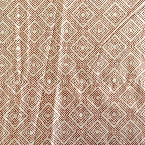 May include: Cream-coloured fabric featuring a repeating pattern of diamond shapes in a reddish-brown hue. The diamonds are outlined with short, diagonal lines, creating a textured effect. The fabric appears to be folded in places.