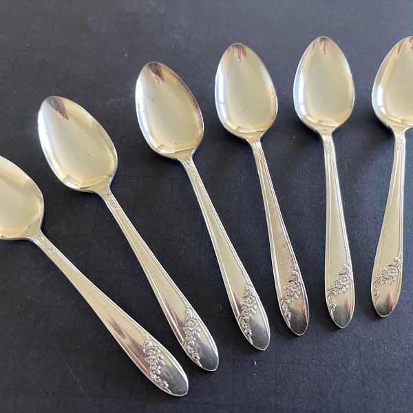 Set of 6 silverplate demitasse spoons by Oneida, shiny silver with spray of roses on bottom handle; each 4.5" long. Selling as a set of 6.