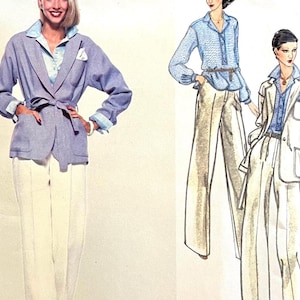 May include: A vintage fashion illustration featuring a woman in a light blue blazer with a matching belt, light blue shirt, and white pants. The blazer has pockets and rolled-up sleeves. The illustration also shows a woman in a blue shirt and beige pants.