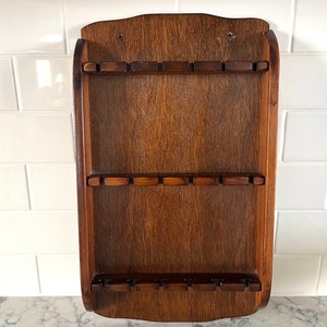 Solid wood spoon holder that hangs on the wall, 18 slots for spoons or other items, excellent condition; 17.25&quot; tall x 10 1/8&quot; wide.
