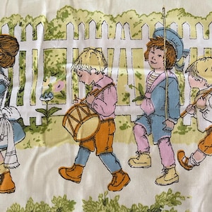 May include: Vintage fabric featuring a parade of children in pastel clothing. The illustration shows children with a drum, flag, and other props, walking past a white picket fence. The color palette includes blue, pink, yellow, and orange.