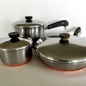 Vintage Revere Ware 1801 copper-bottom stainless steel saucepans and frying pan with lids, selling separately.