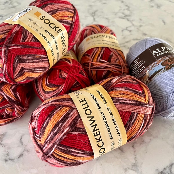 Vintage fine-gauged wool sock yarn, variegated reds or lavender, all new skeins; lavender is alpaca and wool, variegated is all wool.