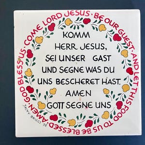 Piastrella decorativa da parete o sottopentola di Jacky Briggs del 1998 con una preghiera da tavola tedesca e motivi floreali; 6" x 6" x 0,25"