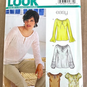 May include: A sewing pattern from New Look featuring designs for women's blouses. The pattern includes illustrations of various blouse styles, including a yellow long-sleeved blouse with flared sleeves, and a white blouse with lace details. The text "easy" is visible.
