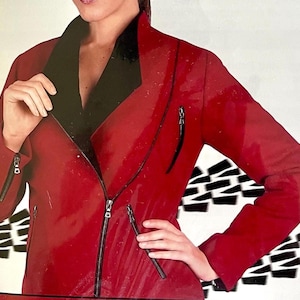May include: A red jacket with a black collar and black zips. The jacket features a diagonal zip closure and zips on the sleeves. The background has a black and white geometric pattern.