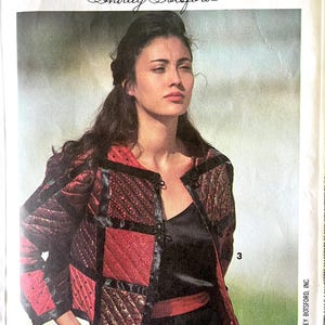 May include: A sewing pattern envelope for Simplicity's School of Quilting by Shirley Botsford featuring a quilted jacket with red and black patchwork panels, black trim, and frog closures, worn over a black top with a red waistband.