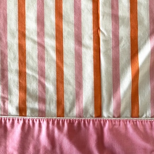 Full- or twin-sized flat Cannon Monticello bed sheet, 50/50 cotton polyester, one stain on full sized, pink piped header.