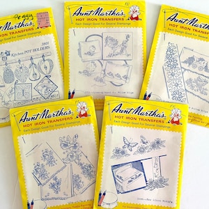 May include: Five yellow packages of Aunt Martha's Hot Iron Transfers for embroidery, textile painting, and other crafts. Each package features a different design, including kitchen pot holders, pillow slips, and linen motifs.  The packages are labeled with the design number and a description of the design.