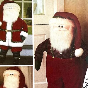 Può includere: Una bambola di Babbo Natale in peluche con un abito rosso, finiture in finta pelliccia bianca e un cappello abbinato. La bambola ha una lunga barba bianca, stivali neri e guanti verdi. Una decorazione natalizia festosa.
