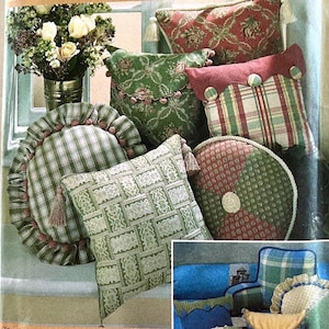 May include: A collection of decorative throw pillows with various patterns and colors, including green, red, and white. The pillows are arranged on a windowsill with a vase of flowers in the background.