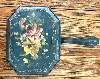 Vintage tole-painted metal silent butler in deep teal green with pink and yellow florals, gold scrolls and lines, paint wear; 11" x 8 5/8".