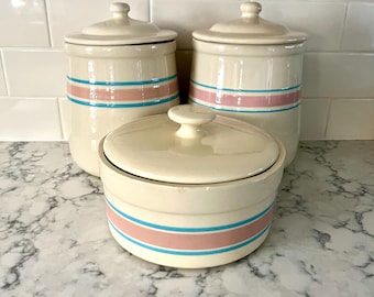 Vintage keramische Nelson McCoy-bussen met bijpassende deksels, traditionele roze en blauwe band rond het midden, wordt apart verkocht.