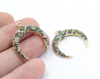 Puede incluir: Dos abalorios de media luna dorados con detalles de cristal de colores. Los abalorios miden aproximadamente 5 cm de largo y tienen un bucle en la parte superior para sujetarlos a joyas.