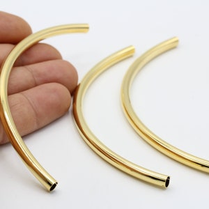 May include: Three gold metal hoops of different sizes. The hoops are smooth and have a shiny finish.