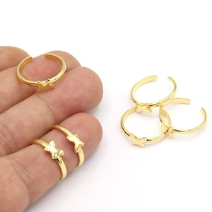 Peut inclure: Ensemble de quatre anneaux de pied dorés avec des motifs de papillons. Les anneaux sont réglables et peuvent être portés sur n'importe quel orteil.
