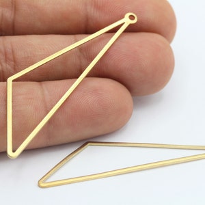 May include: Two gold-colored metal triangle shapes with a small loop at the top. The triangles are open and have a flat, smooth surface.