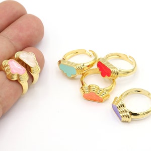 May include: Five gold rings with colourful enamel cloud designs. The rings are stacked on top of each other, with the top ring showing a light blue cloud, the next ring showing a red cloud, the next ring showing an orange cloud, the next ring showing a purple cloud, and the bottom ring showing a white cloud.