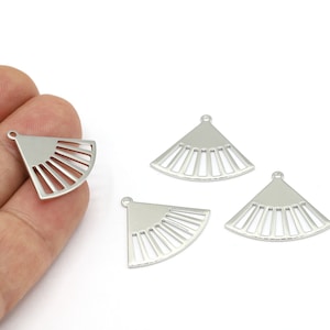 May include: Four silver metal fan-shaped charms with a hole at the top for attaching to jewelry or other crafts.