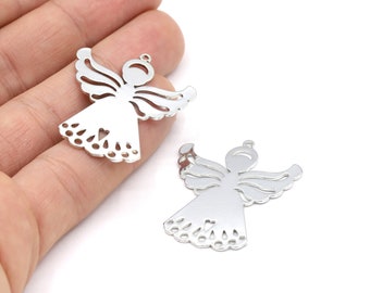 Puede incluir: Dos encantos de ángel plateados con intrincados diseños recortados. Los ángeles tienen alas, un halo y un detalle en forma de corazón en su vestido.