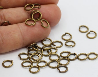 Puede incluir: Un montón de pequeños anillos de salto dorados. Los anillos tienen un diámetro de aproximadamente 1,2 cm y son perfectos para la elaboración de joyas.