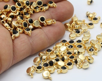 May include: A large quantity of gold-toned metal charms with black round glass stones. Each charm has a small loop for attaching to jewelry or other crafts.