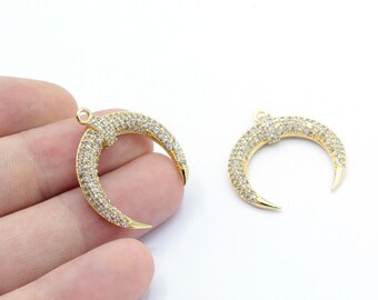 Puede incluir: Dos abalorios de media luna dorados con detalles de cristal transparente. Los abalorios tienen una punta puntiaguda y son perfectos para la elaboración de joyas.
