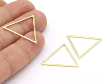 May include: Three gold-colored triangle-shaped jewelry findings. The findings are made of thin metal and have a geometric design. The triangles are empty in the center and are displayed on a white background.