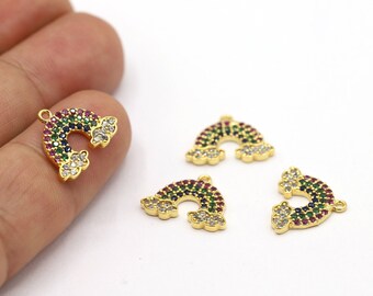 May include: Four gold-tone rainbow charm pendants with clear and colourful crystals. Each charm features a rainbow arch with clouds on either side.
