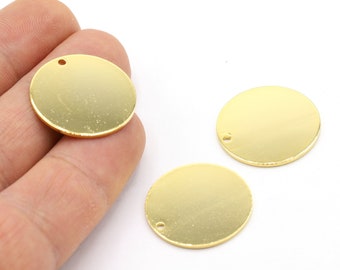 May include: Three gold-colored metal circles with a small hole in the center. The circles are smooth and shiny.