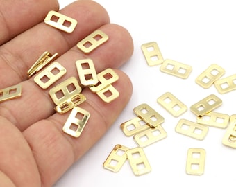 May include: A pile of gold-colored metal rectangular loop connectors. The connectors have two holes in each loop.
