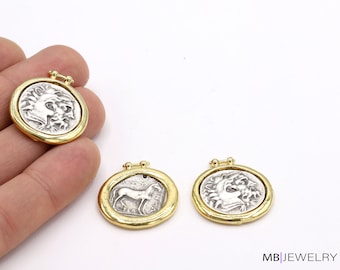 May include: Three gold-toned pendants with silver-toned circular medallions featuring different designs. The medallions have a raised edge and a loop at the top for attaching a chain.