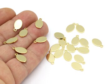 May include: A collection of gold oval-shaped metal charms with a jump ring for attaching to jewelry or other crafts.