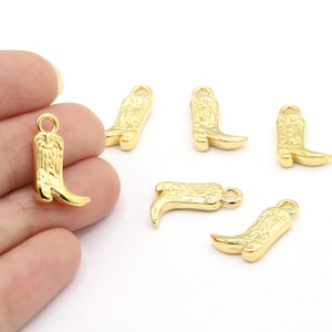May include: Six gold-coloured metal charms shaped like cowboy boots. The charms have a detailed design and a loop at the top for attaching to jewellery.