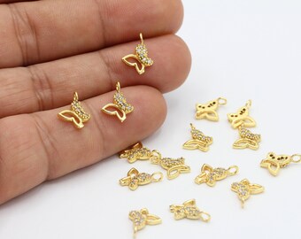 May include: A collection of gold-tone butterfly charms with clear crystal accents. The charms are perfect for jewelry making, scrapbooking, and other craft projects.