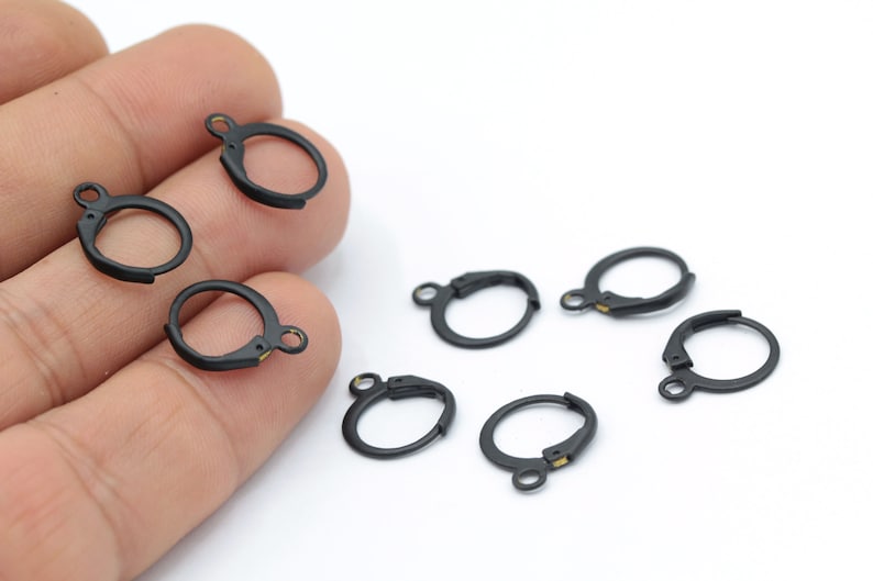 May include: Seven black earring hooks with a gold-colored clasp. The hooks are made of metal and are designed for attaching earrings.