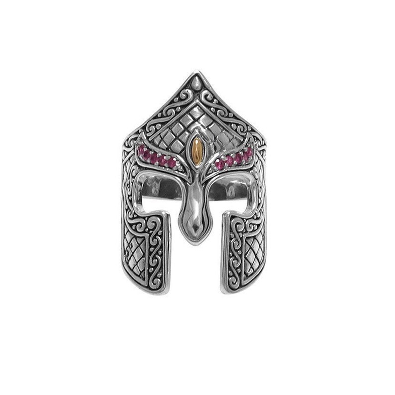 Puede incluir: Un anillo de plata con un dise&ntilde;o detallado de un casco de guerrero. El casco est&aacute; adornado con piedras preciosas rosas y un acento dorado.
