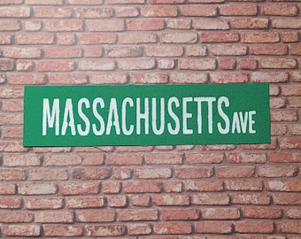 May include: A green street sign with white lettering that reads "MASSACHUSETTS AVE".